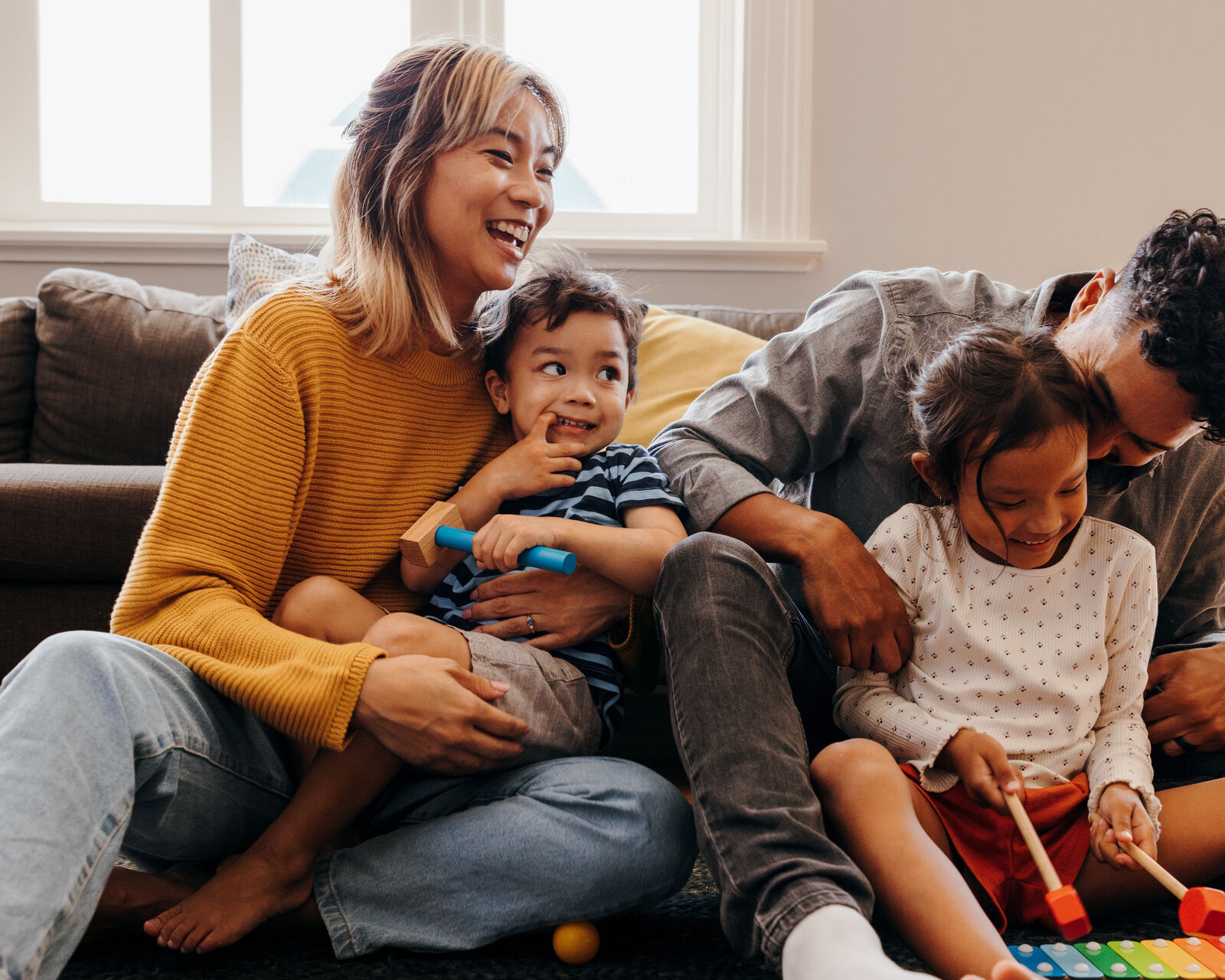 A family playing on the floor with their two little kids
