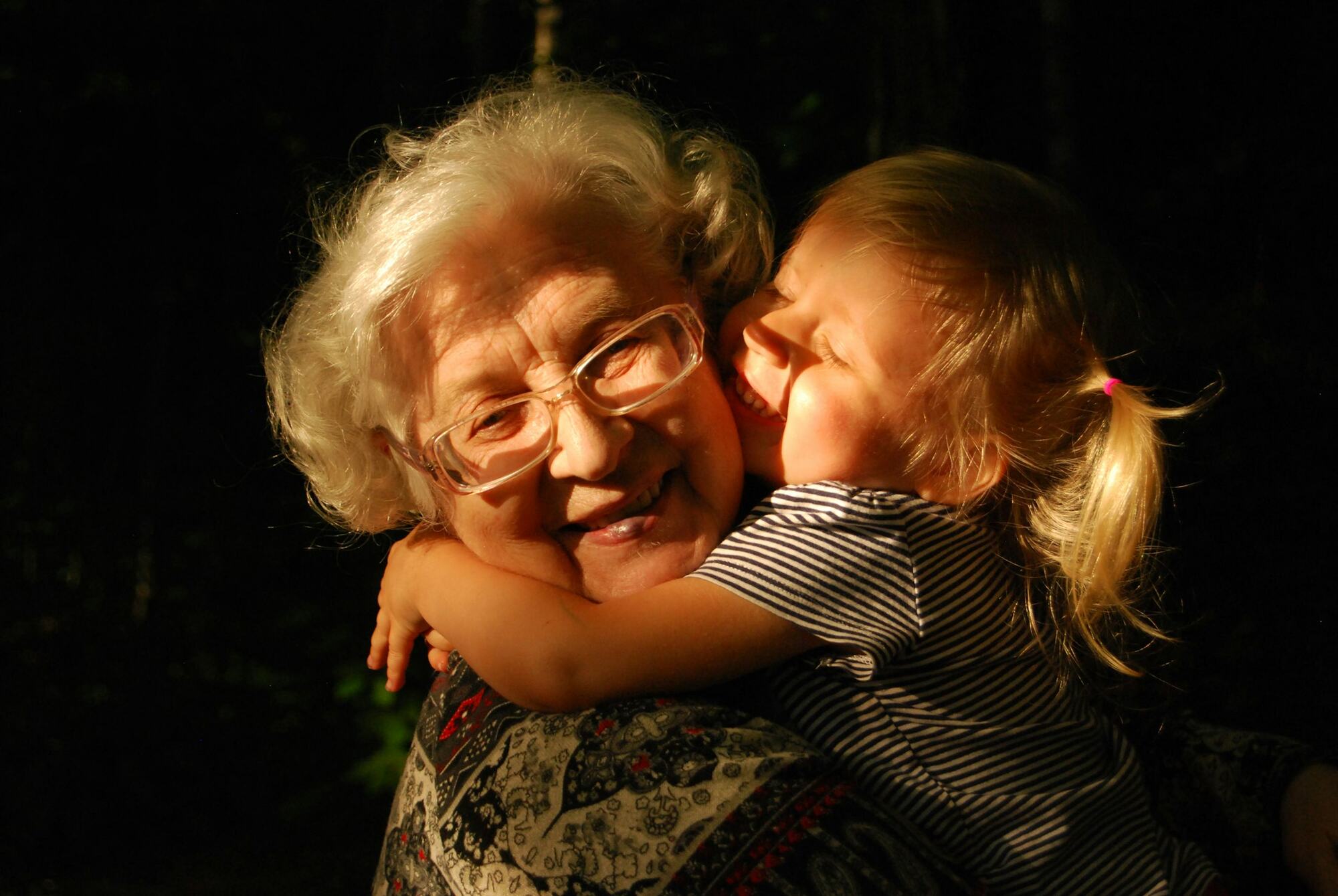 A grandmother hugging her granddaughter close