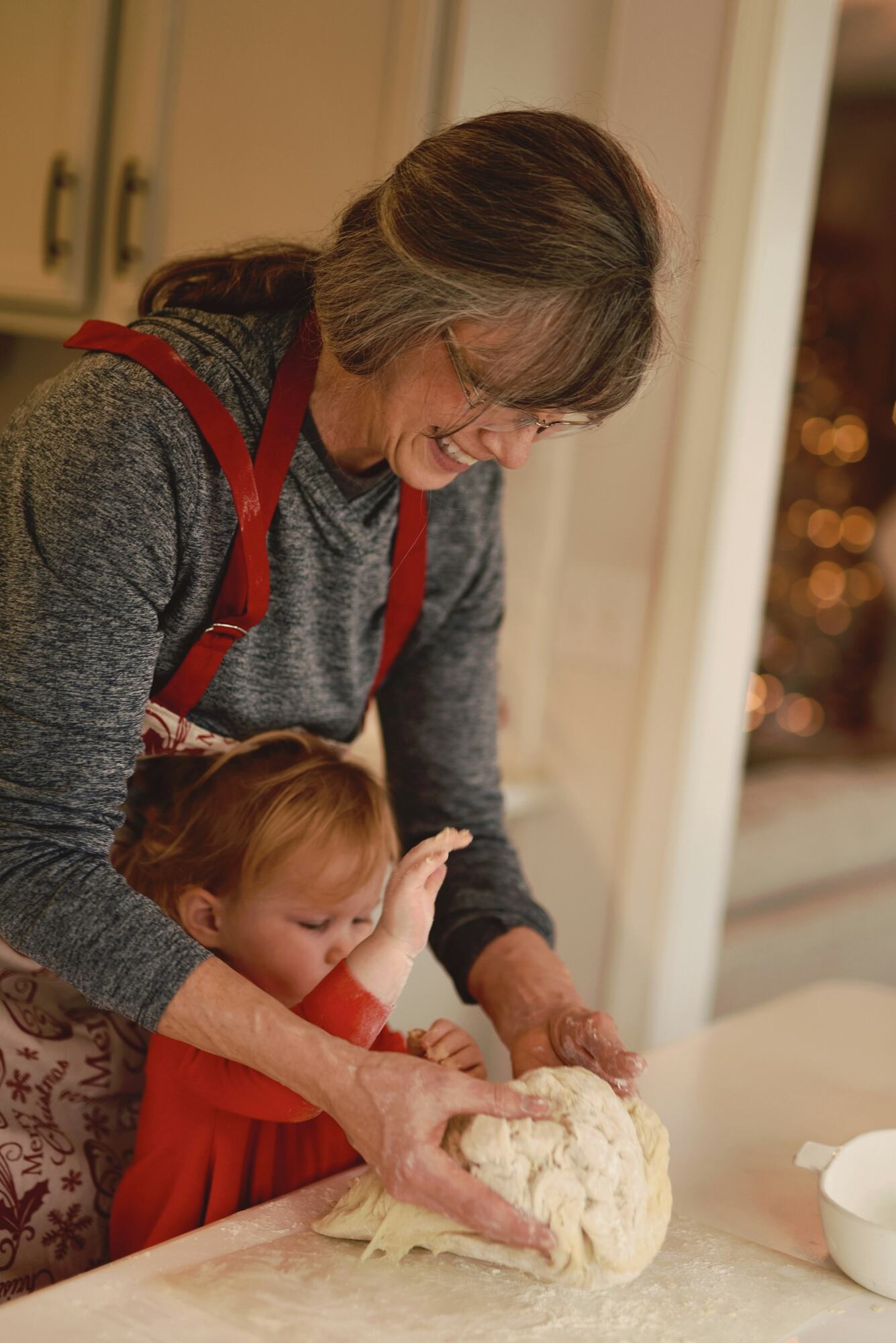 A grandmother baking with her toddler grandson